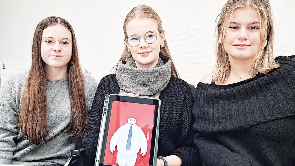 Hannah Nanninga (von links), Annika Kuiper und Mia-Sophie Arndt nehmen mit ihrer virtuellen Bank am »Schulbanker«-Wettbewerb teil. Auf dem Tablet sieht man das Logo ihrer Bank: den »Bankmax«.  © Foto: Berents