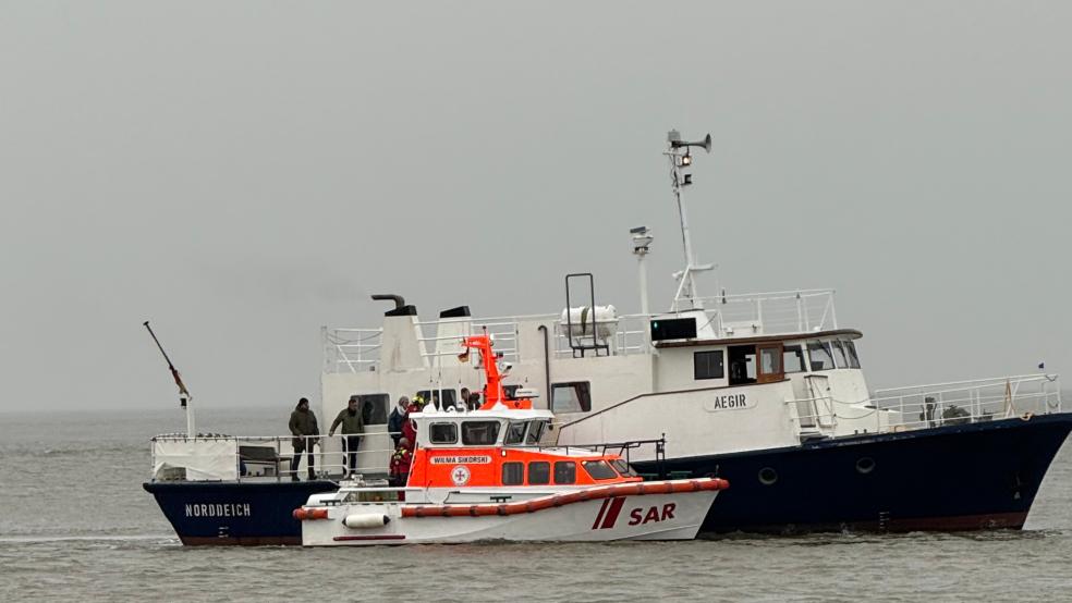 Mit dem Seenotrettungsboot „Wilma Sikorski“ der DGzRS übernehmen die Seenotretter acht Menschen von einem festgekommenen Bestattungsschiff.  © Die Seenotretter