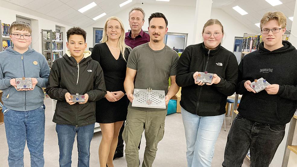 Die Bunder Oberschüler Leon und Esteban (von links) sowie Finn Elias und Nike (von rechts) stellten bei der GenerationenWerkstatt ein eigenes Spiel her. Sie zogen genauso ein positives Fazit des Projekts wie Katrin Marien (Mitte, von links), Holger Pries und Tobias Kohnen von Silgan Dispensing Weener Plastik.  © Foto: Busemann