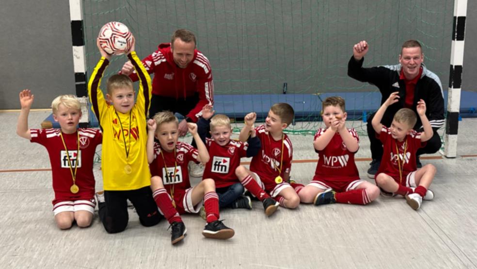 Die G-Junioren des TV Bunde sowie die Trainer Thomas Girod (hinten links) und Stefan Nympsch durften in Friedeburg den Turniersieg beim Strudden-Cup im Kinderfußball feiern. © privat