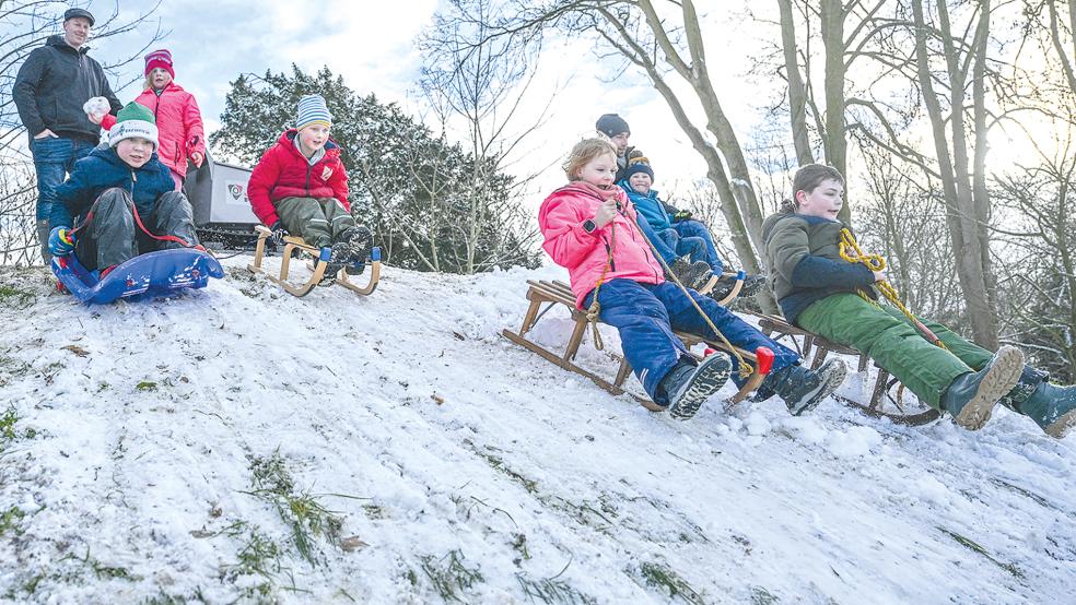 Ralf Bödeker (oben links) setzte die Idee in die Tat um, mit einem kleinen Dumper für ausreichend Schnee auf dem Hügel im Stapelmoorer Park zu sorgen. So bot sich den Kindern eine bestens präparierte Rodelpiste. Die Aktion wurde dankbar angenommen.  © Foto: Bruins