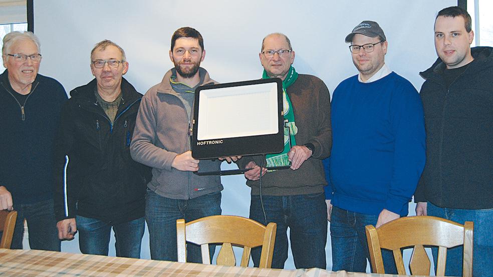Sie präsentieren einen der vier neuen LED-Strahler für die Eislauffläche (von links): Bernhard Siemons (SPD-Ortsverein), Sander Sanders und Hermann Sanders, Herbert Waltemathe (Teutonia Stapelmoor), Kim Uwe Siemons (Dorfverein) und Dennis Modder (Feuerwehr).  © Foto: Hoegen