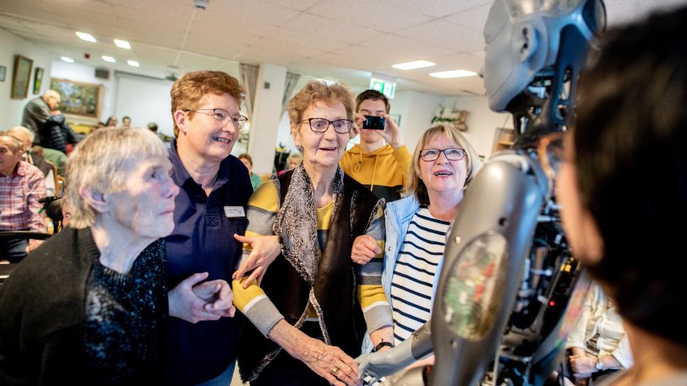 Die Seniorinnen Johanne Kück (links) und Marga Ehlert (Dritte von links) sowie die Claudia Lindner (Zweite von links) und Irene Preyk, beide aus dem Team für soziale Betreuung im Haus Friede, sprechen während einer Vorstellung in dem Alten- und Pflegeheim mit dem humanoiden Roboter »Ameca«, während Ingenieurin Celia Nieto Agraz (rechts) die Funktionen erklärt. © Foto: Dittrich (dpa)