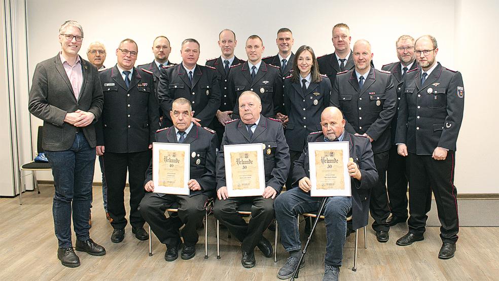 Auszeichnungen und Glückwünsche für langjährige Treue überreichten (hinten von links) Bürgermeister Heiko Abbas, Ortsvorsteher Friederich Sap, Stadtbrandmeister Jörg Fisser und der stellvertretende Stadtbrandmeister Steffen Voss an Christopher Murra, Stefan Luitjens, Matthias Spengel, Tammo Schmidt, Janka Erfkamp-Vry, Hans-Jürgen Mülder, Christian Reck, Lars Battermann, Ewald Spengel und Andreas Bruns (alle 25 Jahre). Eine Urkunde für besonders lange Mitgliedschaft erhielten (vorne von links) Frank Köller (40 Jahre), Peter Glowczewski (50 Jahre) und Hans-Jürgen Mülder (50 Jahre).  © Foto: Rand/Feuerwehr