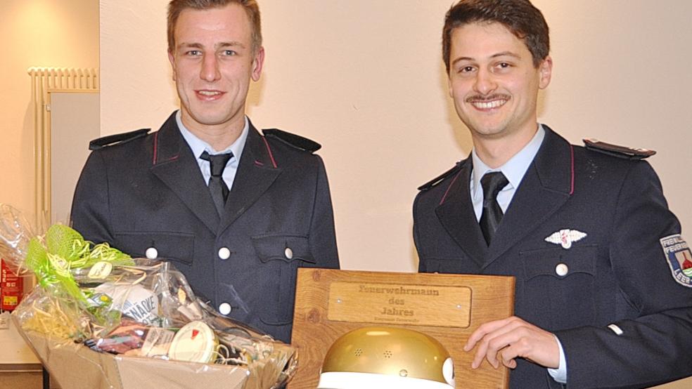 Aus den Händen des stellvertretenden Ortsbrandmeisters Yannick Geib (rechts) nahm Julian Runge einen Präsentkorb und die Auszeichnung als Bingumer »Feuerwehrmann des Jahres 2025« entgegen. © Foto: Wolters