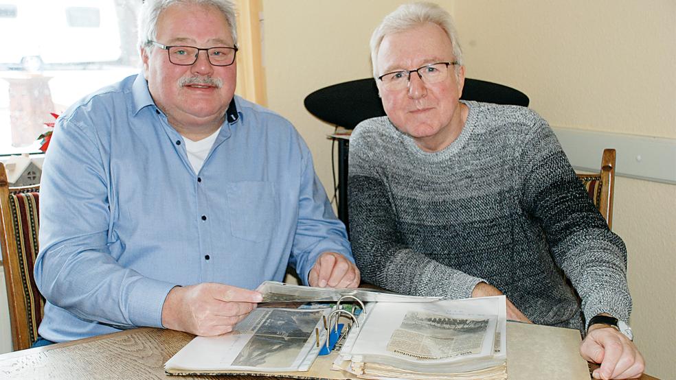 Die langjährigen Bunder Feuerwehrmänner Ingfried Battermann und Wilfried Appel blättern in alten RZ-Berichten über die Feuerwehr Bunde.  © Foto: Hoegen