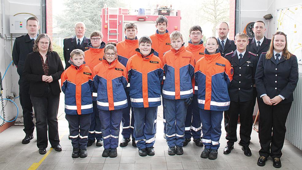 Das Gruppenfoto zeigt die Jugendfeuerwehr Holthusen und (von links) die stellvertretende Bürgermeisterin Insa Wutschke, den stellvertretenden Kreisjugendfeuerwehrwart Arno Yzer und Stadtjugendfeuerwehrwart Ewald Freese sowie (von rechts) Jugendfeuerwehrwartin Janna Schmehl, Ortsbrandmeister Stefan Siemens, Betreuer Oliver Jans und den stellvertretenden Stadtbrandmeister Steffen Voss.  © Foto: Rand