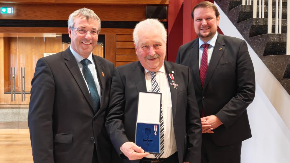 Landschaftspräsident Rico Mecklenburg (Mitte) erhielt das Verdienstkreuz am Bande des Niedersächsischen Verdienstordens. Überreicht wurde es von Emdens Oberbürgermeister Tim Kruithoff (rechts), Staatssekretär Johann Saathoff hielt eine Laudatio auf Plattdeutsch. © Foto: Becker