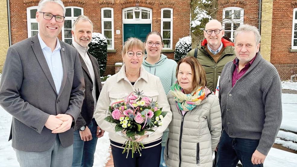 Albertje Podgorski-Lubbers (vorne) wurde in Begleitung ihres Mannes Michael Podgorski (Zweiter von rechts) in den Ruhestand verabschiedet. Bürgermeister Heiko Abbas (von links), Hermann Welp (Erster Stadtrat), Sarah Möhlmann (Gleichstellungsbeauftragte), Ingeborg Gosewinkel-Reier (Leiterin Kindergarten Stapelmoor) und Robert Sonnenberg (Personalratsvorsitzender) wünschten ihr alles Gute.  © Foto: Stadt Weener