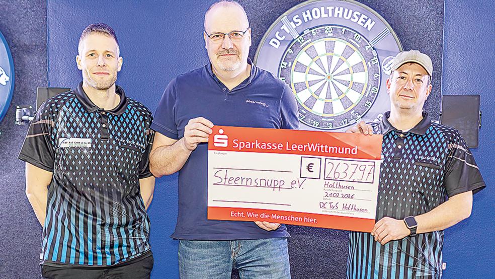 Markus Gernand (links) und Timo Schoormann (rechts) vom DC TuS Holthusen übergaben Heiner Kruse vom Verein Steernsnupp einen symbolischen Scheck über 2637,97 Euro.  © Foto: Jungeblut